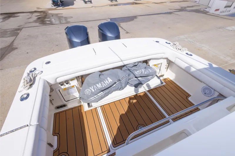 Slide: The Image of 2018 Regulator 31 boat deck with Yamaha engines, featuring teak flooring and white seating. - 48