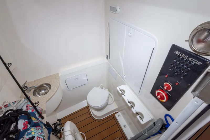 Slide: The Image of 2018 Regulator 31 boat bathroom with sink, toilet, and control panel. - 51