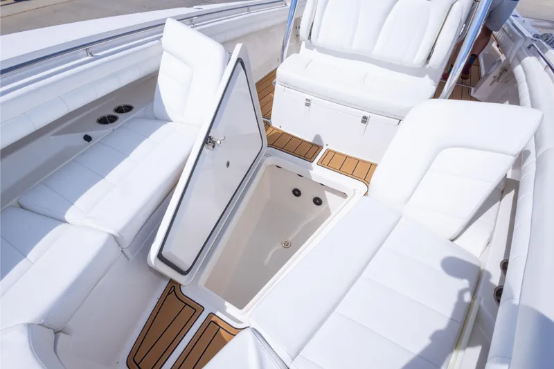 Slide: The Image of 2018 Regulator 31 boat interior with open storage compartment and white seating. - 54