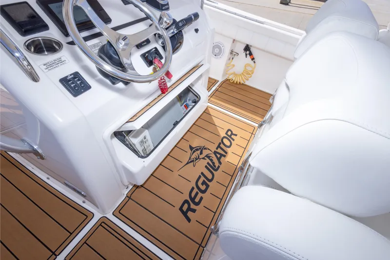Slide: The Image of 2018 Regulator 31 boat interior with steering wheel and branded flooring. - 60