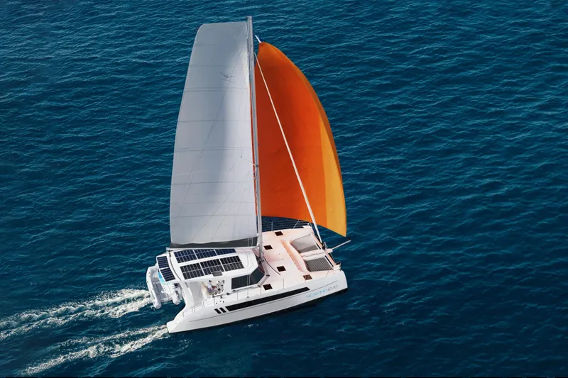 The Image of 2026 Seawind 1270 catamaran sailing with orange and white sails on open ocean. - 0