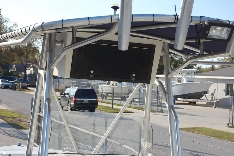 Slide: The Image of 2005 Sea Hunt Triton 220 boat with T-top and street view in background. - 12