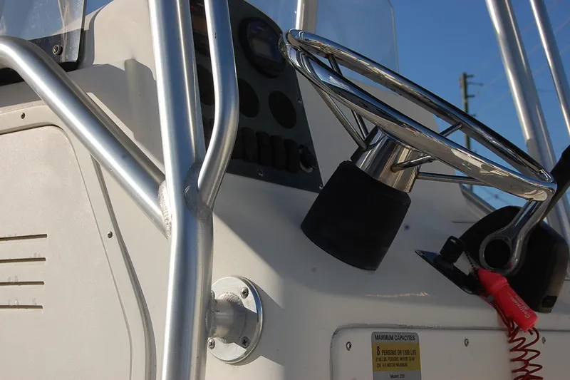 Slide: The Image of Steering wheel of 2005 Sea Hunt Triton 220 boat, featuring stainless steel details. - 13