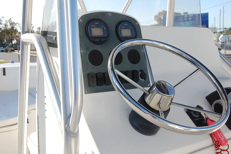Slide: The Image of 2005 Sea Hunt Triton 220 boat dashboard with steering wheel and gauges. - 14