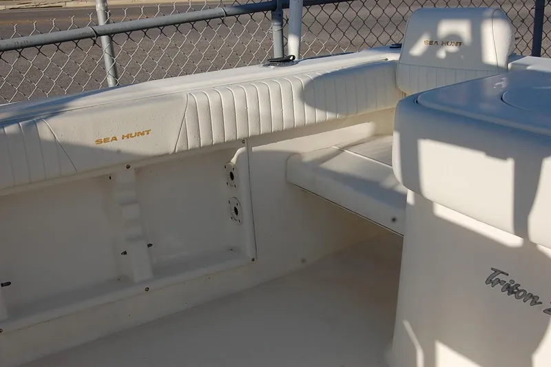 Slide: The Image of 2005 Sea Hunt Triton 220 boat interior with white seating and branding. - 15