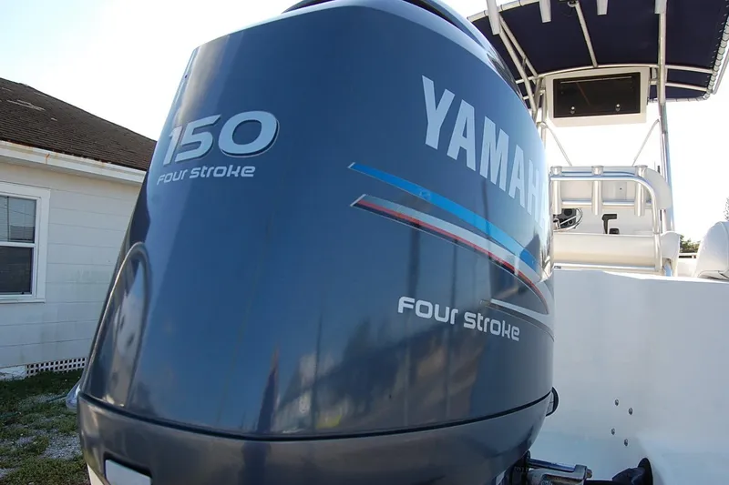 Slide: The Image of 2005 Sea Hunt Triton 220 with Yamaha 150 four-stroke engine, docked near a house. - 6