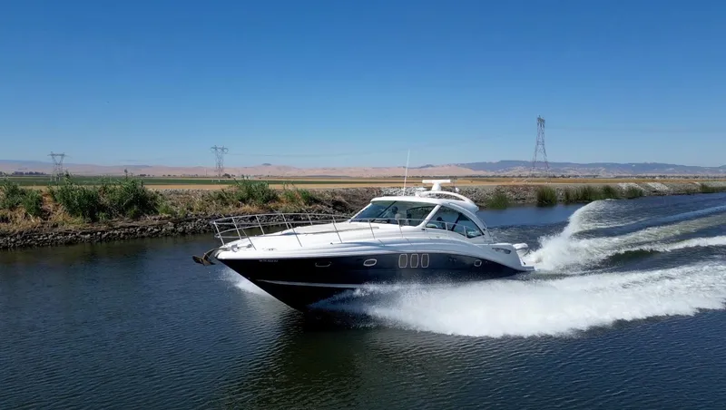 Slide: The Image of 2008 Sea Ray 48 Sundancer cruising swiftly on a river. - 2
