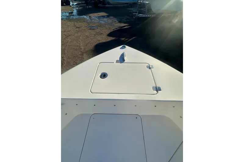 Slide: The Image of 2021 Cobia 220 Center Console boat deck with storage hatch in sunlight. - 14