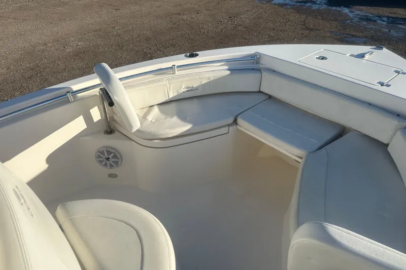 Slide: The Image of 2021 Cobia 220 Center Console boat interior with white seating and steering wheel. - 16