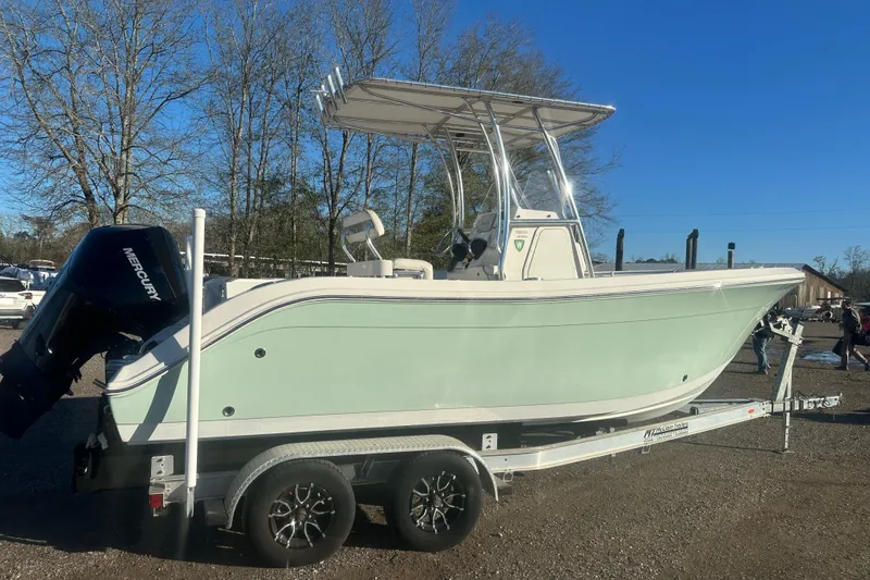 Slide: The Image of 2021 Cobia 220 Center Console boat on trailer, side view, outdoors. - 2