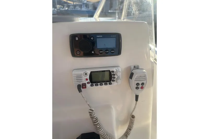 Slide: The Image of 2021 Cobia 220 Center Console boat dashboard with radio and communication devices. - 20