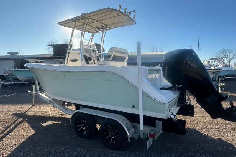 Slide: The Image of 2021 Cobia 220 Center Console boat on trailer, featuring a powerful outboard motor. - 6