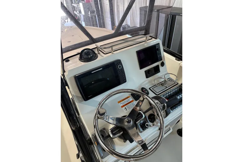 Slide: The Image of 2020 Triton 22 LTS boat console with steering wheel and navigation equipment. - 2