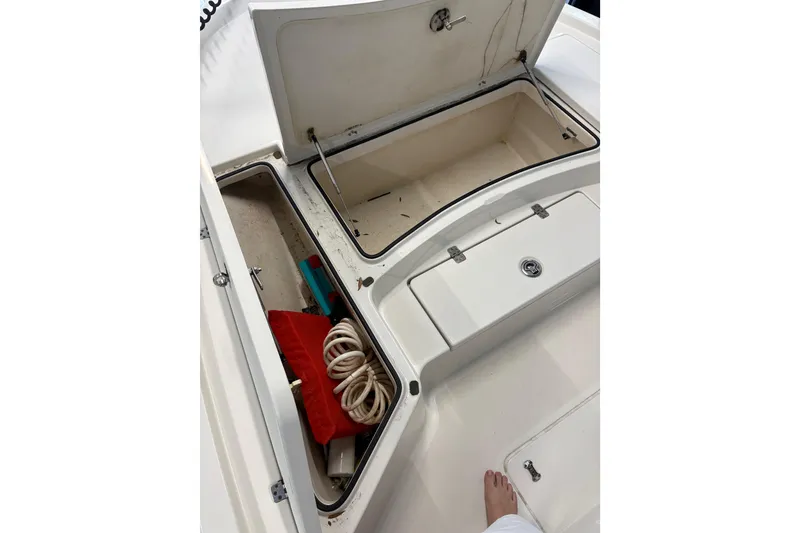 Slide: The Image of Open storage compartments on a 2020 Triton 22 LTS boat, showing ropes and equipment. - 3