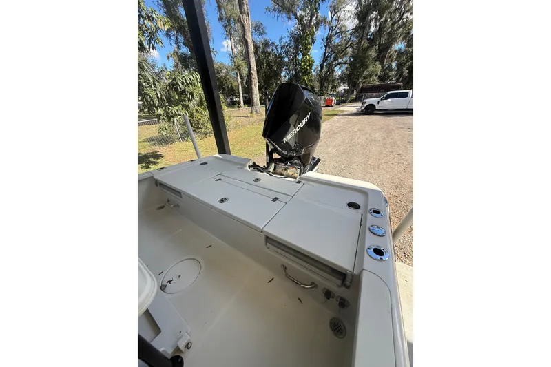 Slide: The Image of 2020 Triton 22 LTS boat with Mercury engine, parked outdoors on a sunny day. - 6