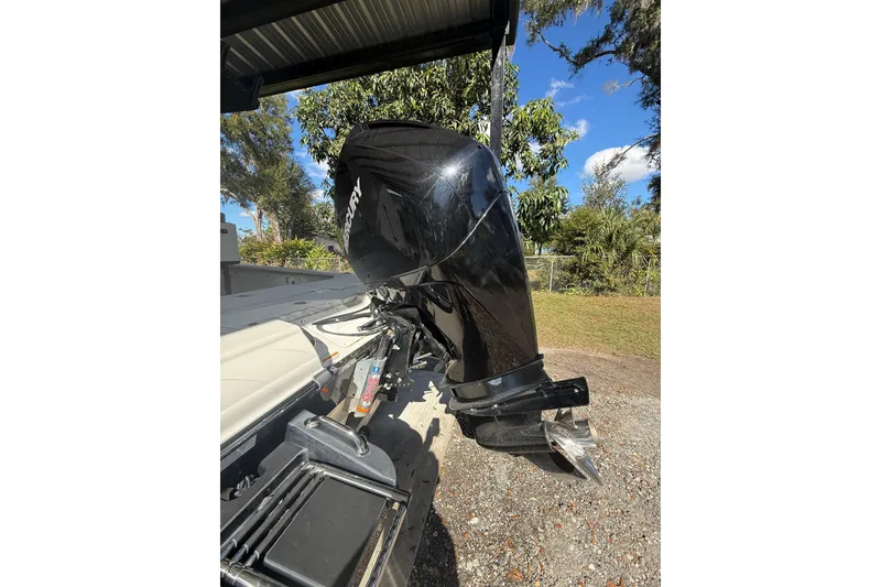 Slide: The Image of 2020 Triton 22 LTS boat with Mercury outboard motor, parked outdoors. - 7