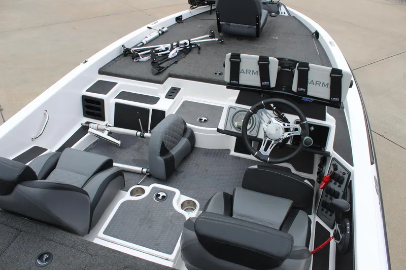 Slide: The Image of 2021 Caymas CX 18 SS boat interior with steering wheel, seats, and fishing rod holders. - 8