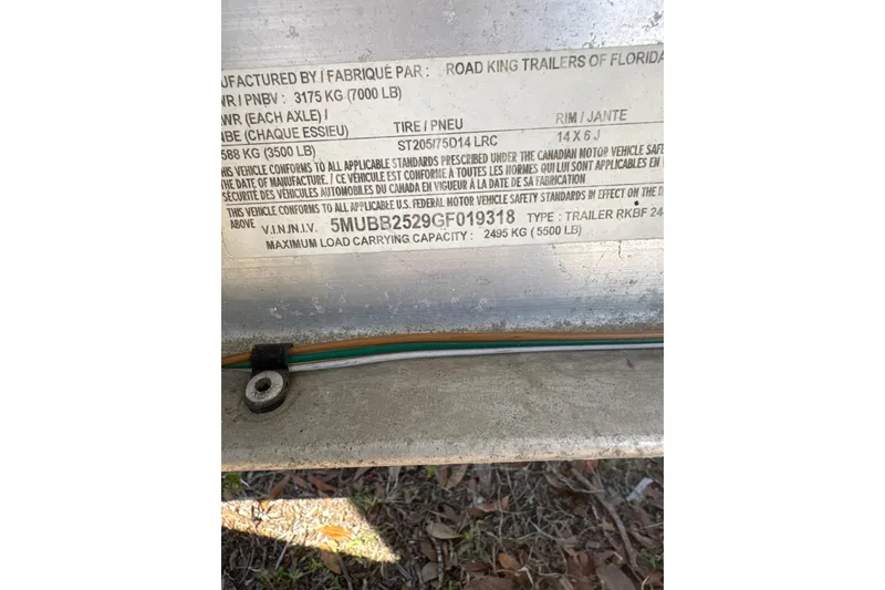 Slide: The Image of 2016 Crevalle 26 Bay boat with trolling motor, parked on gravel, surrounded by trees. - 13