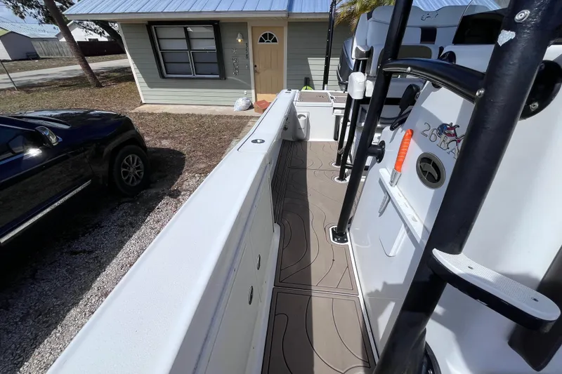 Slide: The Image of 2016 Crevalle 26 Bay boat parked beside a house with a blue roof. - 17