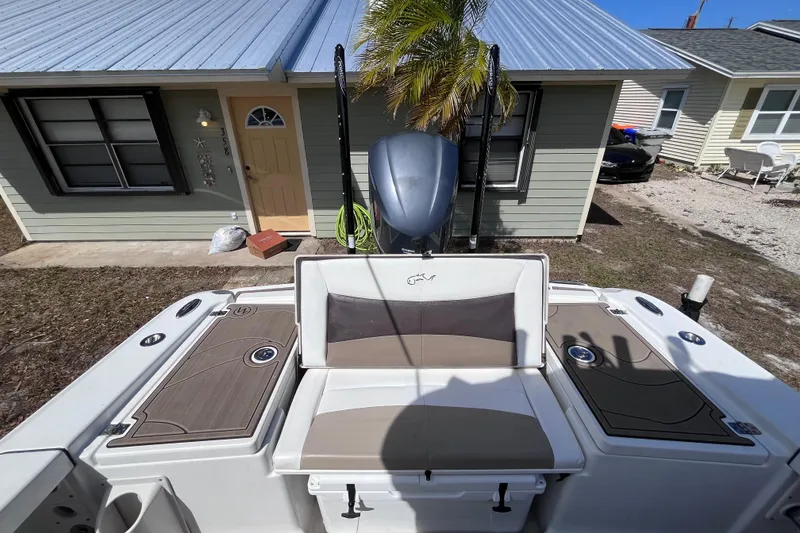 Slide: The Image of 2016 Crevalle 26 Bay boat parked in front of a house with a metal roof. - 19