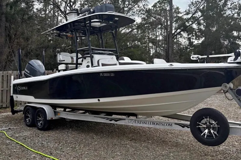 Slide: The Image of 2016 Crevalle 26 Bay boat on trailer in residential driveway, clear blue sky. - 2