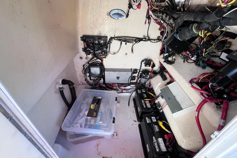Slide: The Image of 2016 Crevalle 26 Bay boat wiring and battery compartment with organized cables and storage. - 28