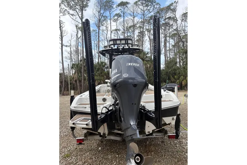 Slide: The Image of 2016 Crevalle 26 Bay boat on trailer with Yamaha outboard motor, parked outdoors. - 4