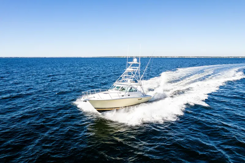 The Image of 2002 Pursuit 3800 Express boat cruising on open blue water. - 1