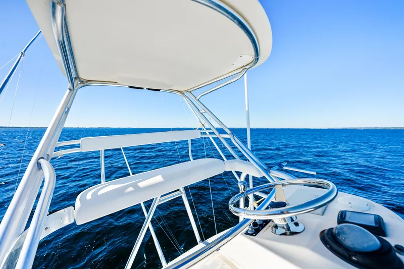 Slide: The Image of 2002 Pursuit 3800 Express boat helm with ocean view under clear blue sky. - 12
