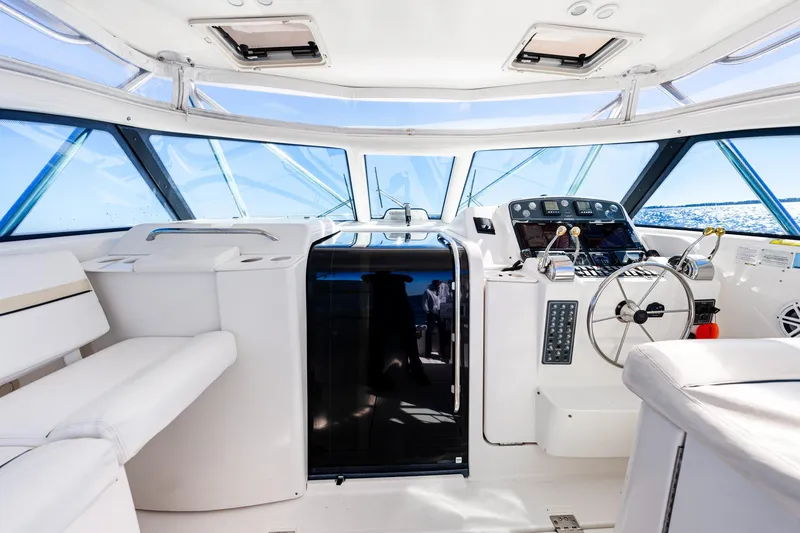 Slide: The Image of 2002 Pursuit 3800 Express yacht interior with helm, seating, and panoramic windows. - 19