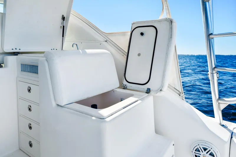 Slide: The Image of 2002 Pursuit 3800 Express boat interior with storage compartments, open hatch, and ocean view. - 24