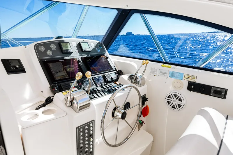 Slide: The Image of Cockpit of 2002 Pursuit 3800 Express boat with steering wheel and control panel, ocean view. - 26