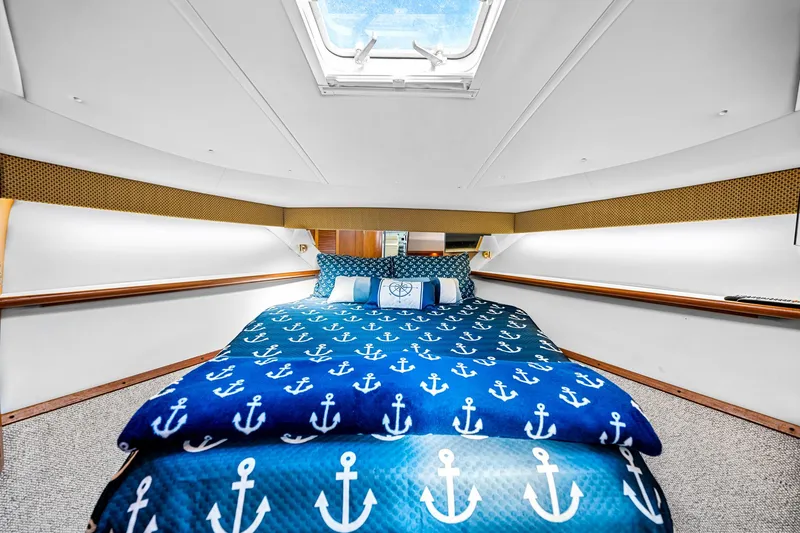 Slide: The Image of Luxurious cabin interior of 2002 Pursuit 3800 Express with nautical-themed bedding. - 32