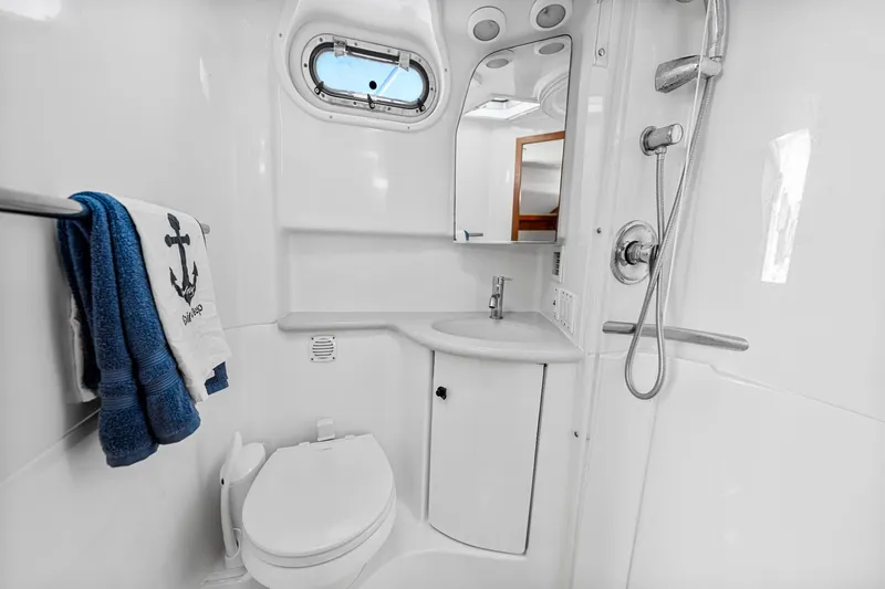 Slide: The Image of 2002 Pursuit 3800 Express yacht bathroom with shower, sink, and nautical-themed towel. - 35