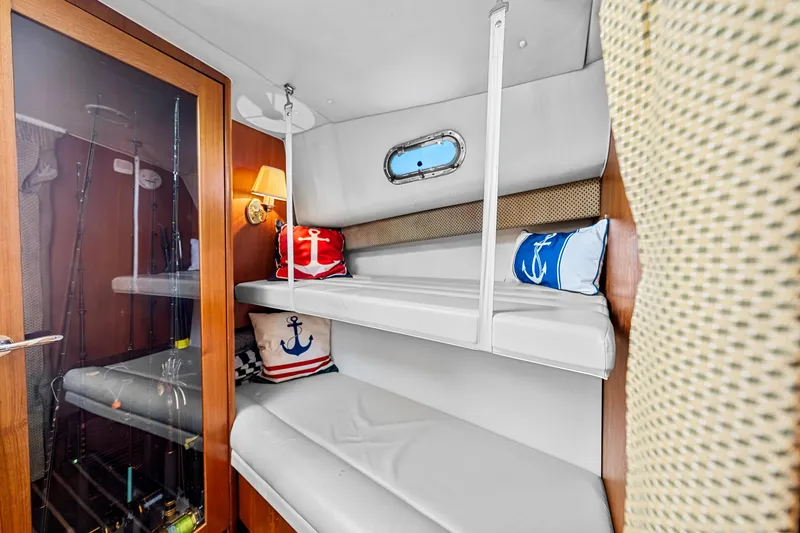 Slide: The Image of Interior of 2002 Pursuit 3800 Express boat with bunk beds and nautical decor. - 37