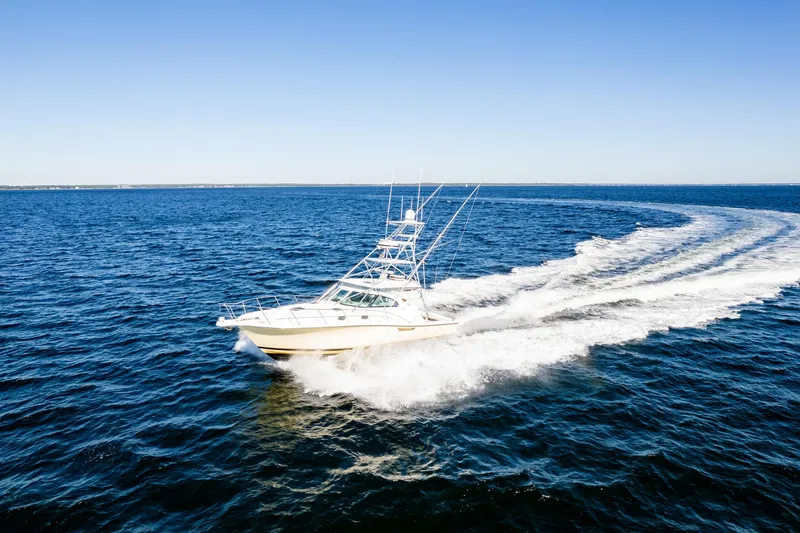 Slide: The Image of 2002 Pursuit 3800 Express boat cruising on open ocean under clear blue sky. - 4