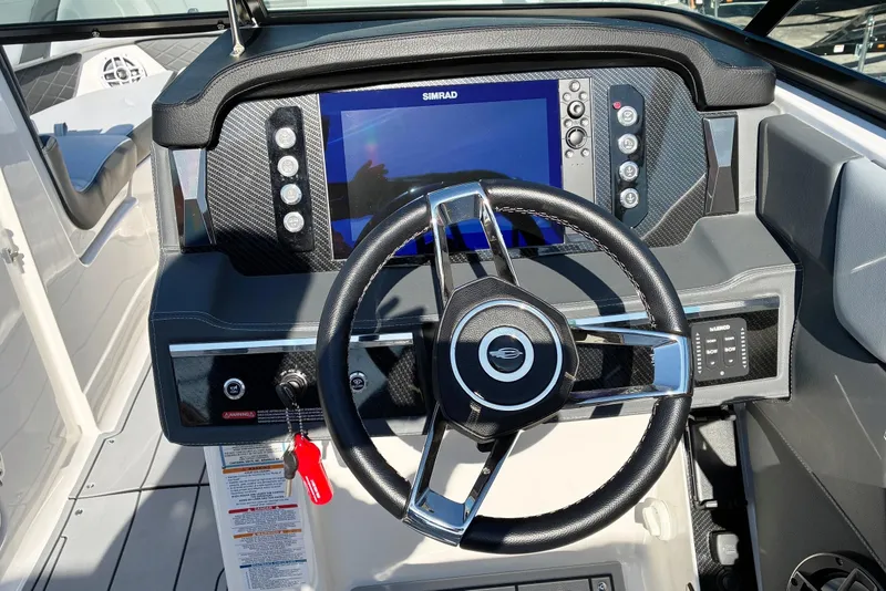 Slide: The Image of 2025 Chaparral 267 SSX boat dashboard with steering wheel and digital display. - 12
