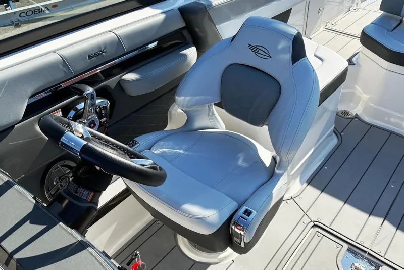Slide: The Image of 2025 Chaparral 267 SSX boat cockpit with luxurious seating and modern steering wheel design. - 15