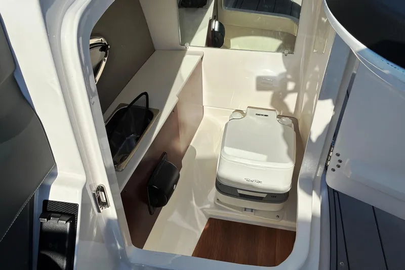 Slide: The Image of Interior of 2025 Chaparral 267 SSX boat featuring compact marine toilet. - 17
