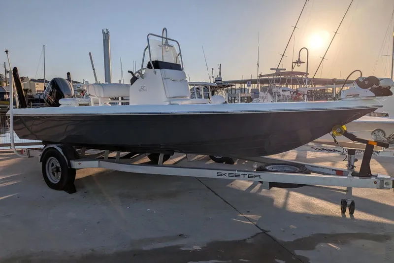 Slide: The Image of 2017 Skeeter SX200 boat on trailer at marina during sunset. - 2