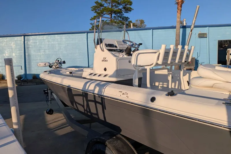 Slide: The Image of 2017 Skeeter SX200 boat in a marina, featuring a sleek white and gray design. - 7