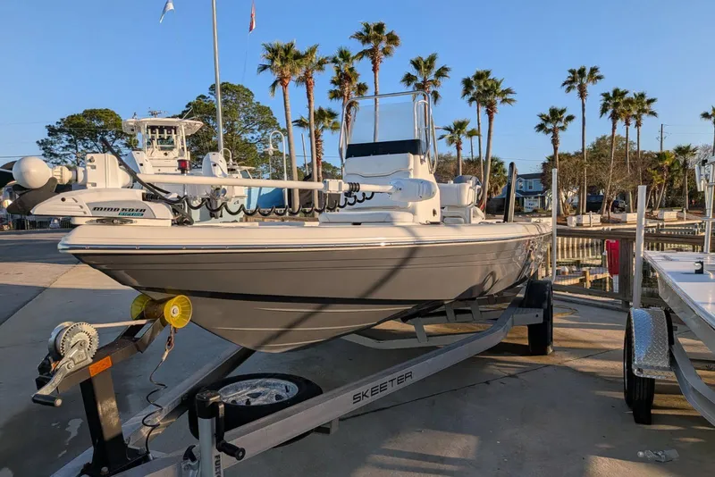 Slide: The Image of 2017 Skeeter SX200 boat console with seating, palm trees in background. - 9