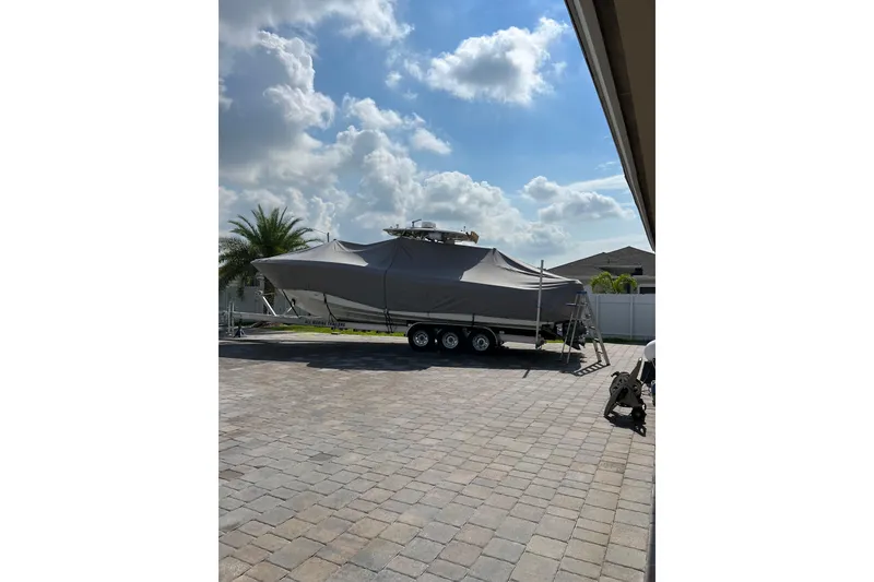 Slide: The Image of 2006 Hydra-Sports Vector 3300 CC boat covered on a trailer in a sunny driveway. - 13