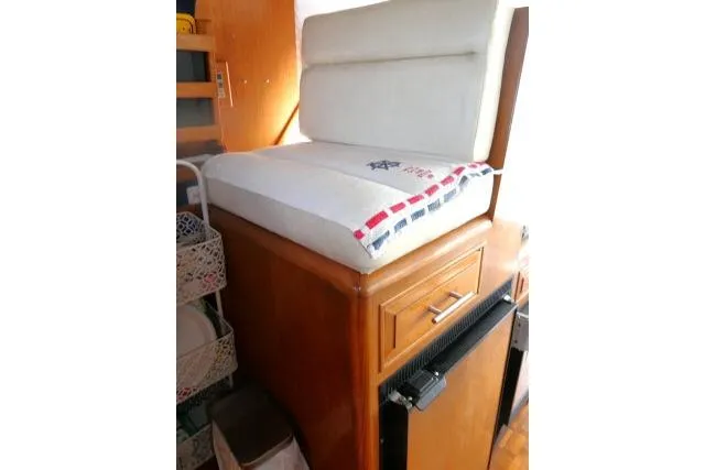 Slide: The Image of 1986 Ocean Alexander 39 Sedan interior with cushioned seating and wooden cabinetry. - 10