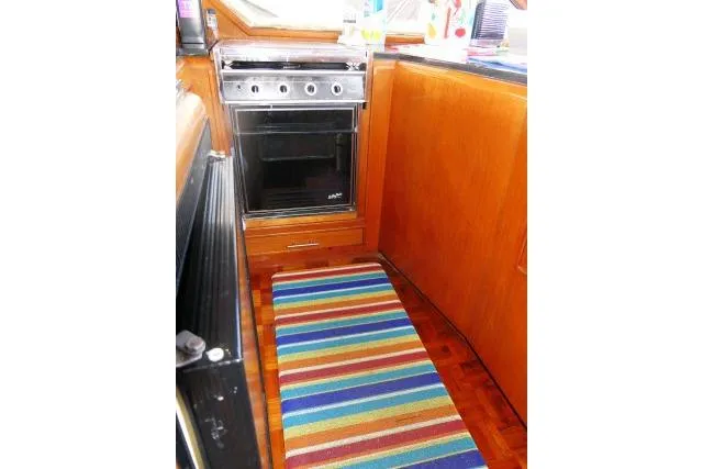 Slide: The Image of 1986 Ocean Alexander 39 Sedan kitchen with stove and colorful striped rug. - 18