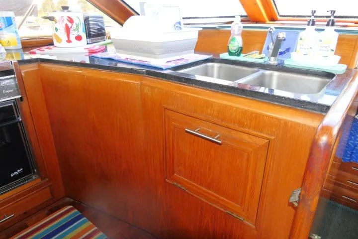 Slide: The Image of 1986 Ocean Alexander 39 Sedan kitchen with wooden cabinetry and double sink. - 19