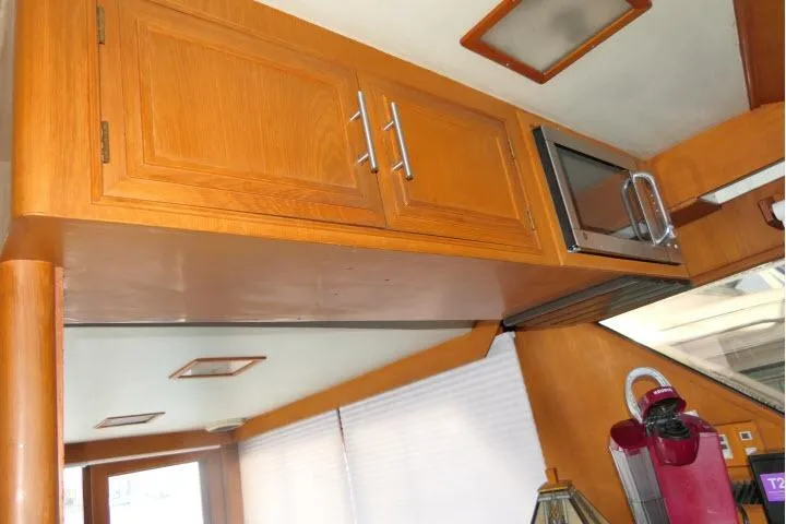 Slide: The Image of 1986 Ocean Alexander 39 Sedan interior with wooden cabinets and modern appliances. - 20