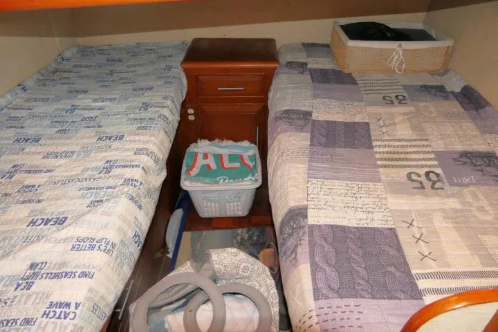 Slide: The Image of 1986 Ocean Alexander 39 Sedan cabin with twin beds and wooden nightstand. - 23