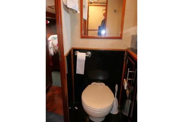 Slide: The Image of 1986 Ocean Alexander 39 Sedan yacht bathroom with toilet, mirror, and storage. - 26