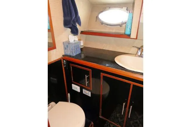 Slide: The Image of 1986 Ocean Alexander 39 Sedan bathroom with sink, mirror, and porthole window. - 27